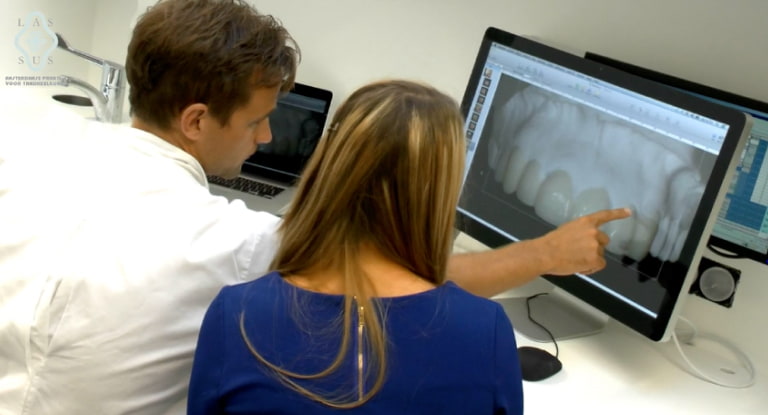 A dentist showing a client options for dental facings